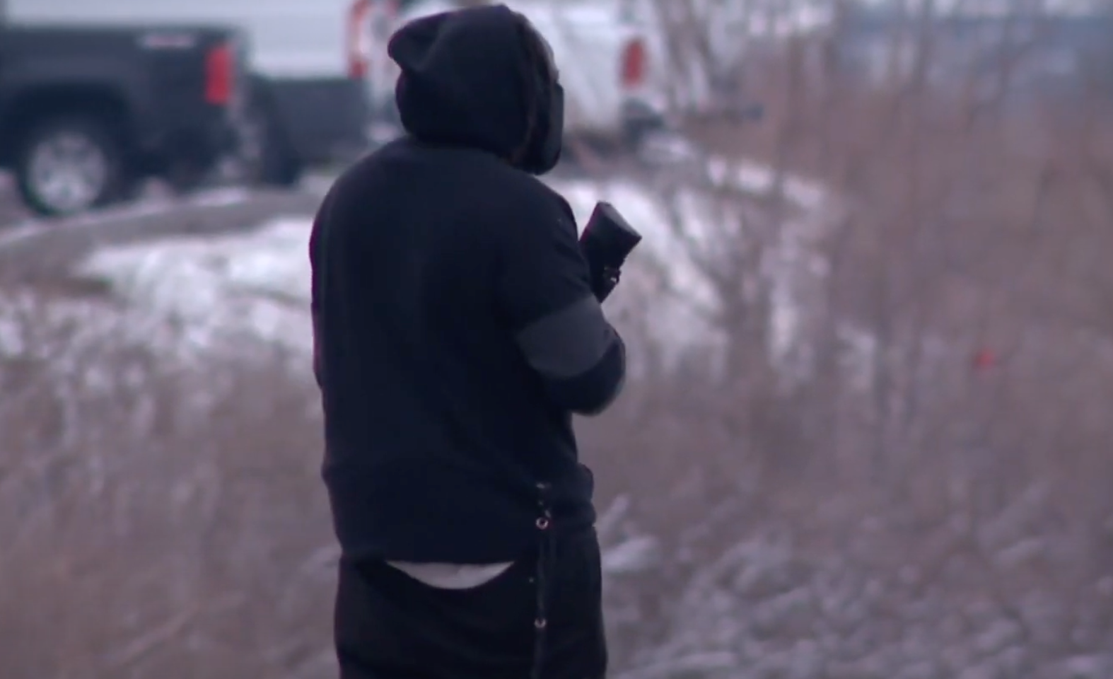 A hooded armed civilian patrols the Lincoln Heights neighborhood near Cincinnati, Ohio, following a February 7 incident in which neo-Nazis held a rally on a nearby highway overpass