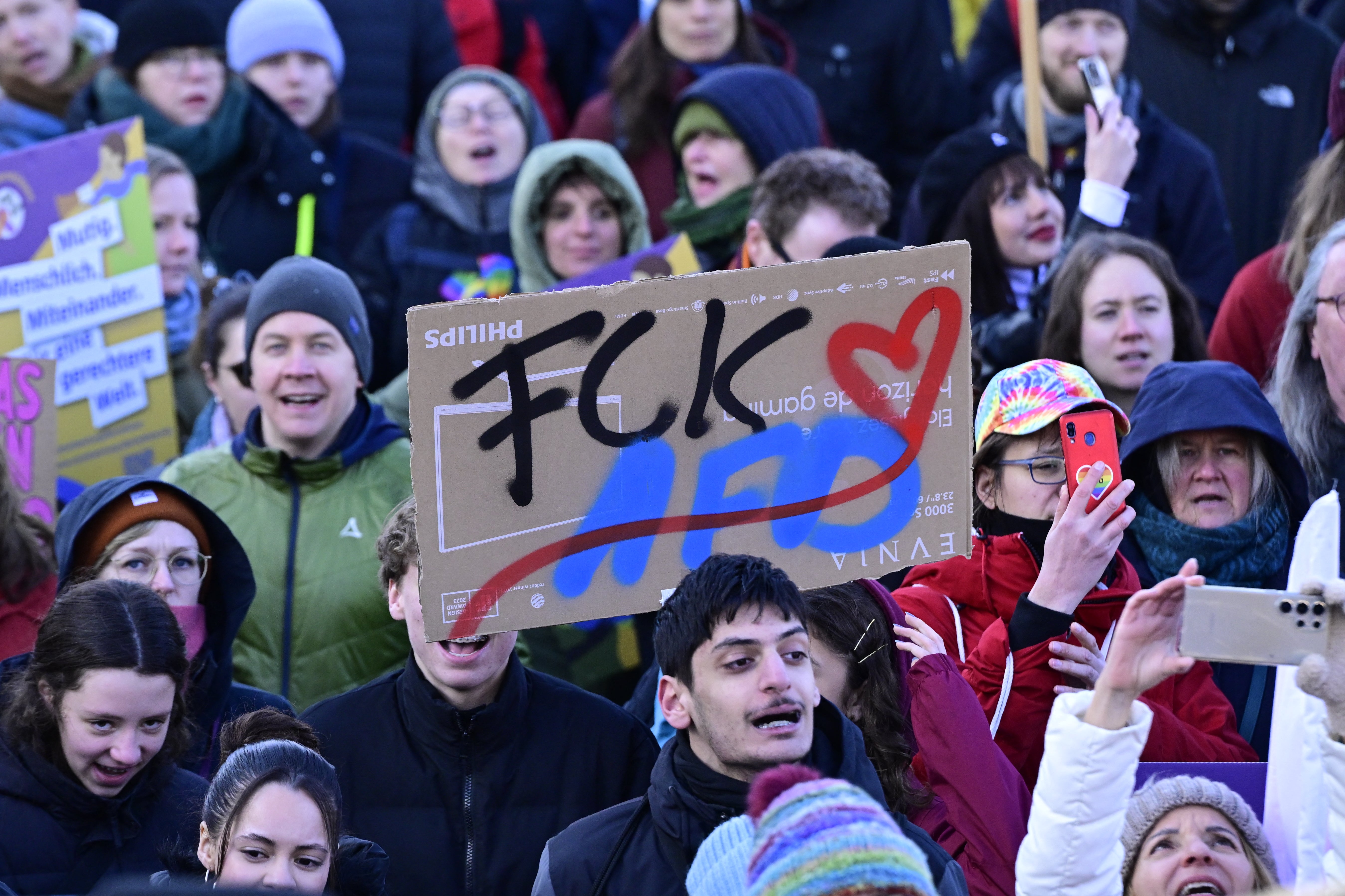 A demonstrator holds up a placard reading "FCK AfD" (Alternative for Germany) during a protest against the far right in Berlin on February 16