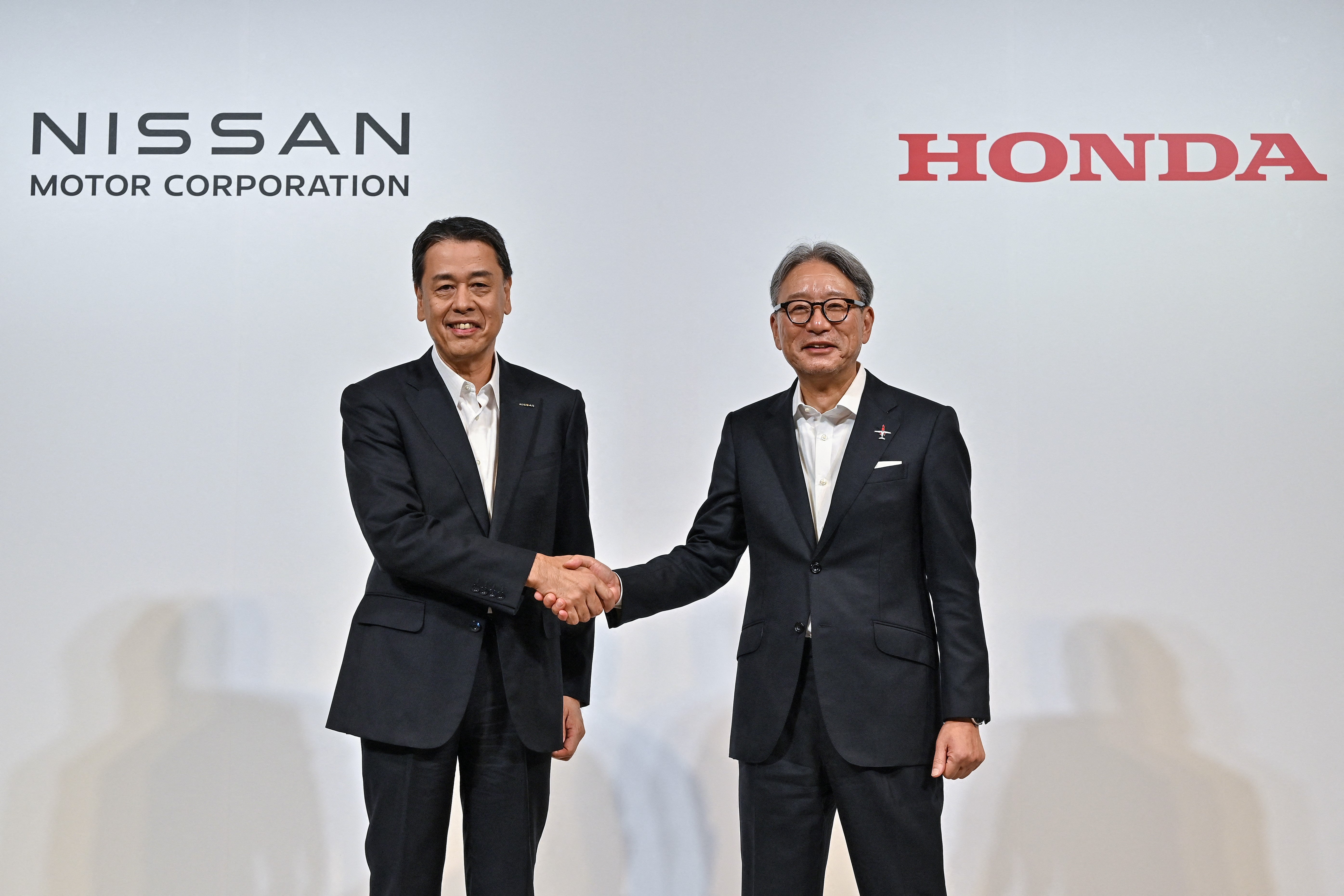 File Makoto Uchida (L), president and CEO of Japanese auto maker Nissan, shakes hands with Toshihiro Mibe (R), director, president and representative executive officer of auto maker Honda, following a press conference in Tokyo on August 1, 2024