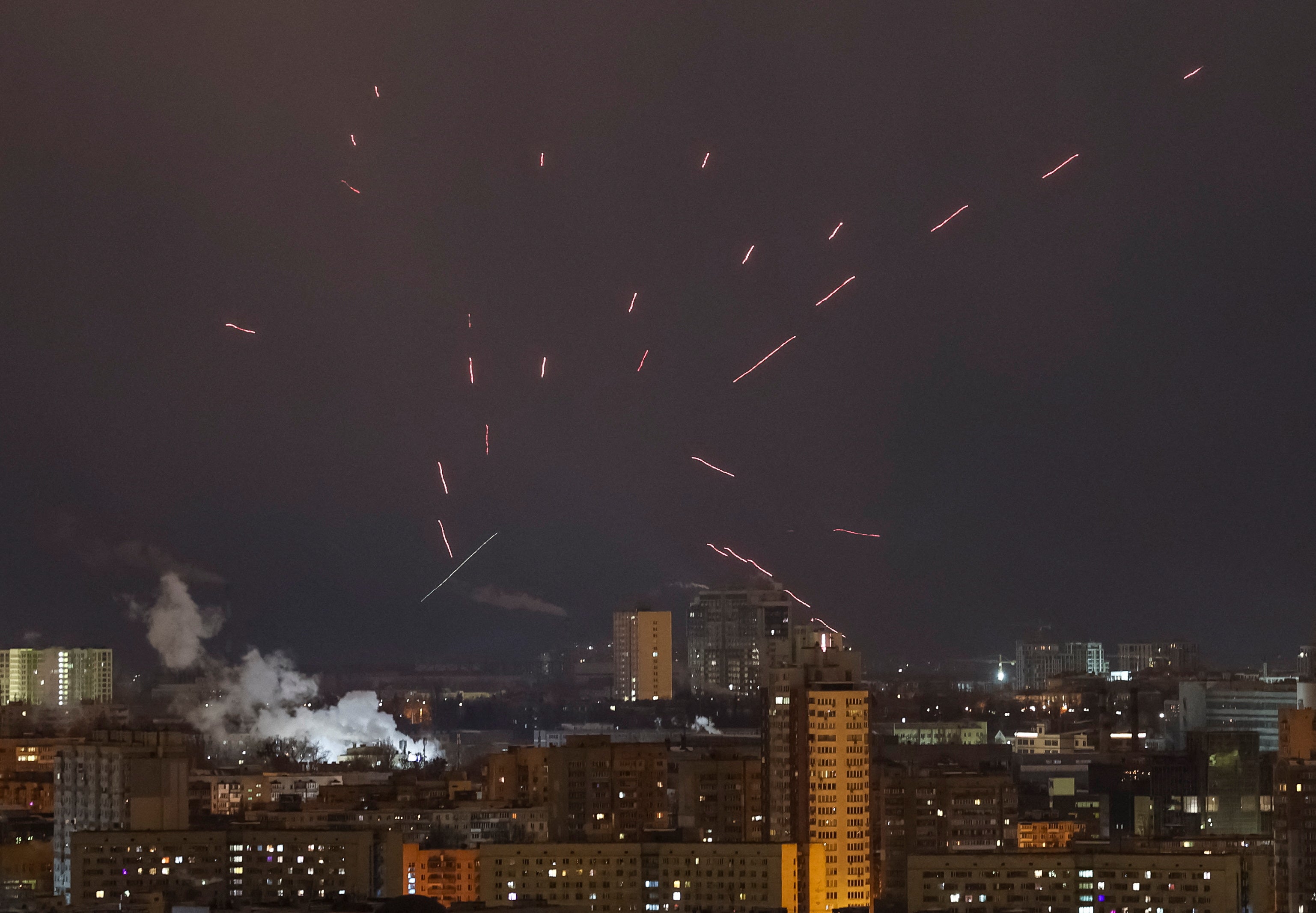 Tracers are seen in the night sky as Ukrainian servicemen fire at a drone during a Russian attack on Kyiv