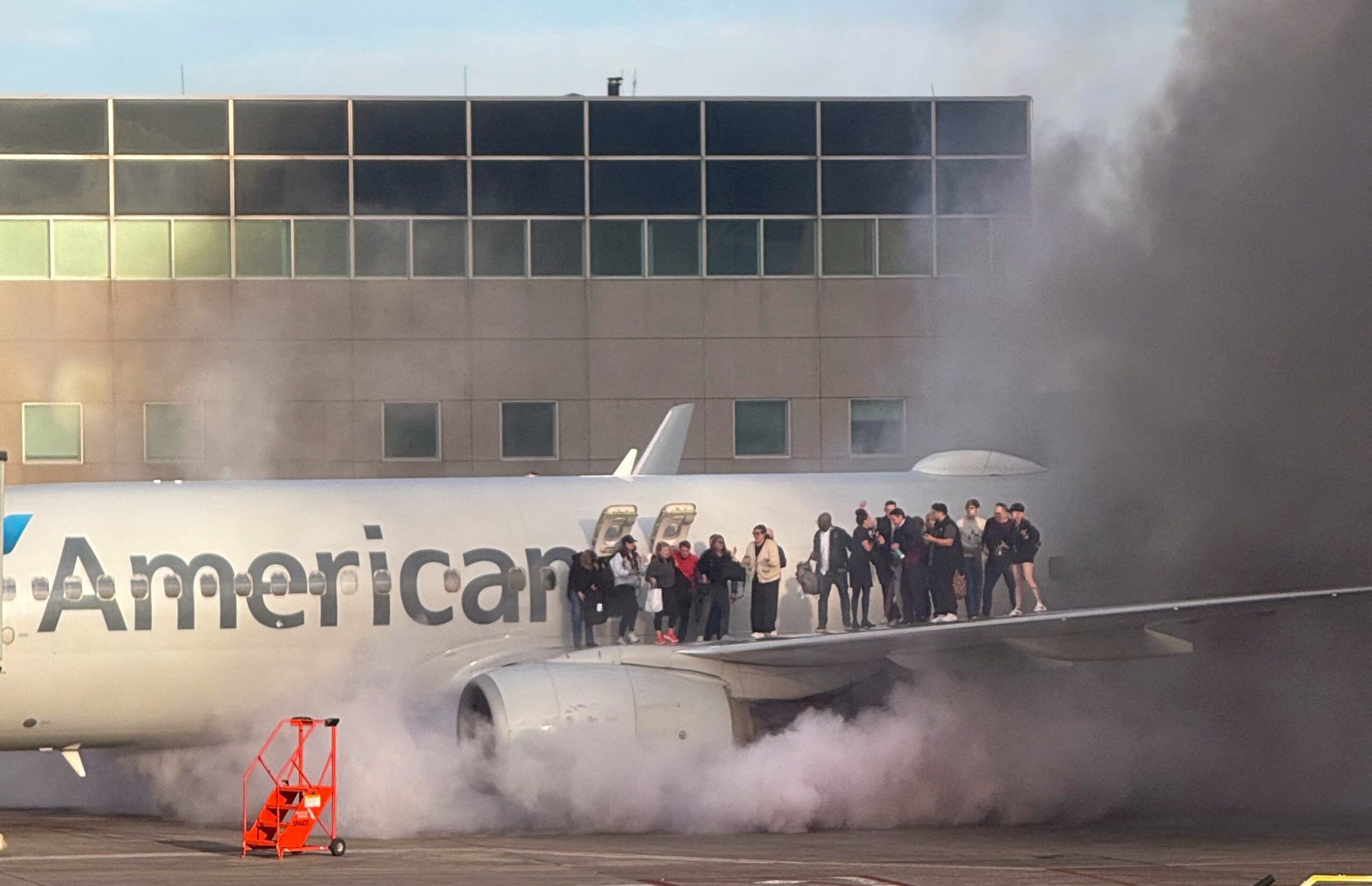 American Airlines plane catches fire on runway as passengers flee via the wing