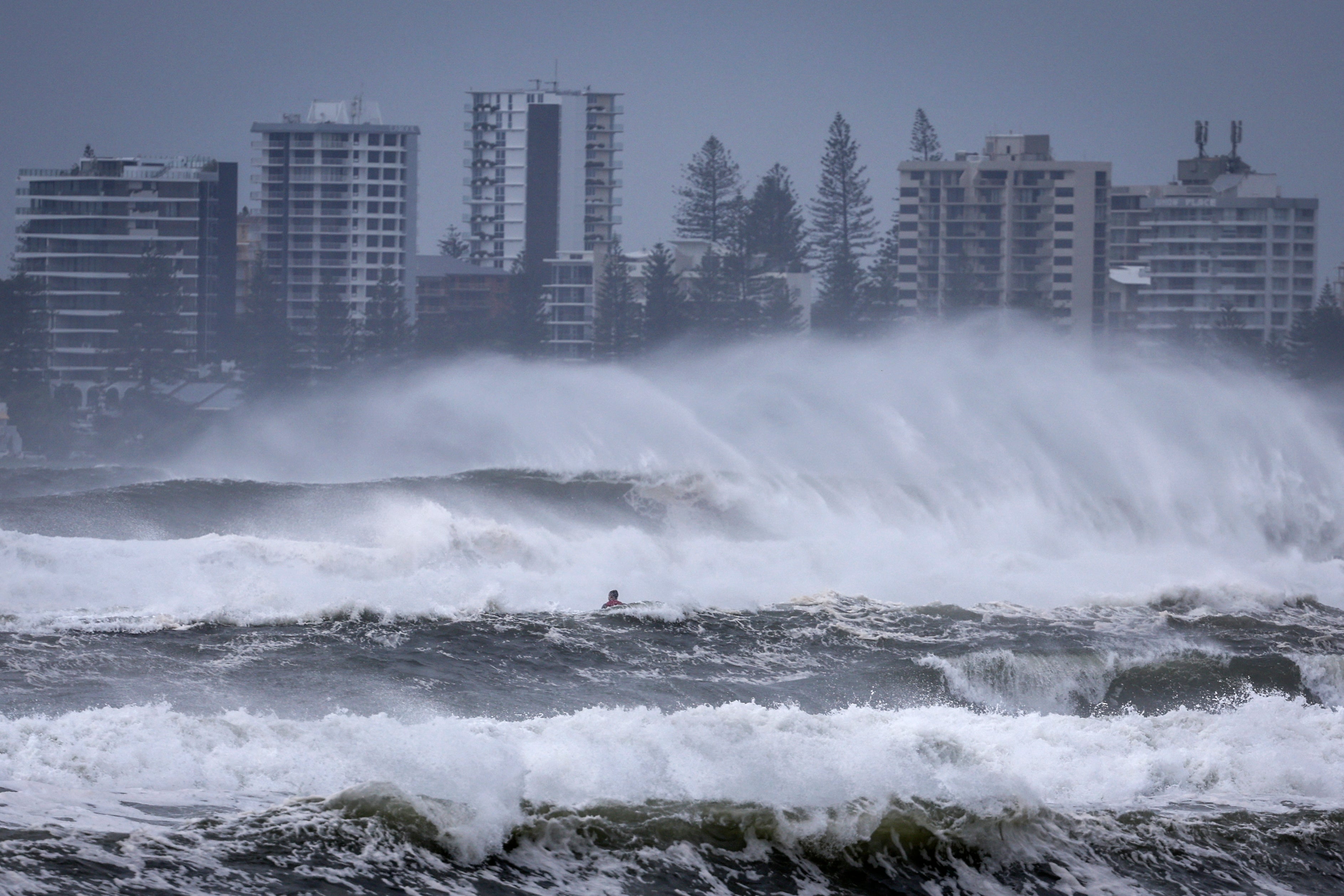 A jet ski with a surfer moves across record-breaking waves at Kirra Beach