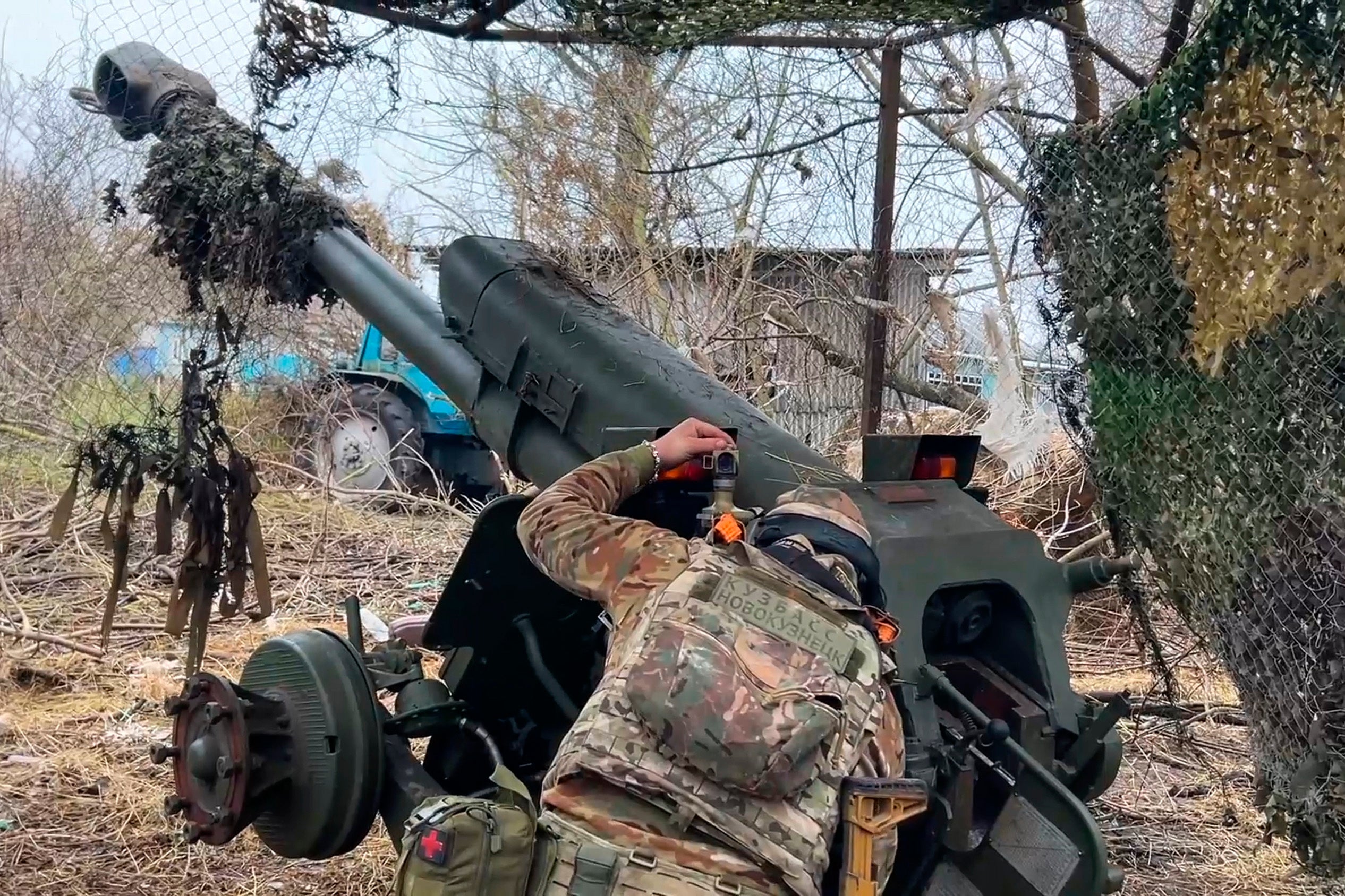 A Russian serviceman aims a D-30 howitzer towards Ukrainian positions in the Kursk region, in November 2024